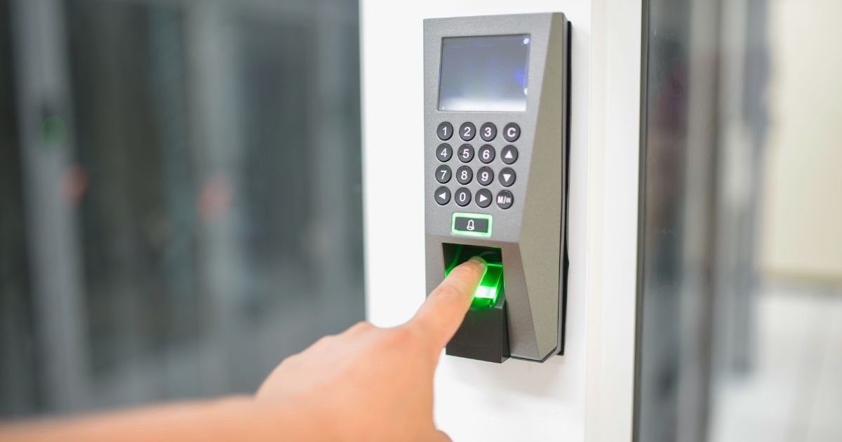 Door Access Control (Person using a fingerprint biometric door access control reader with keypad)